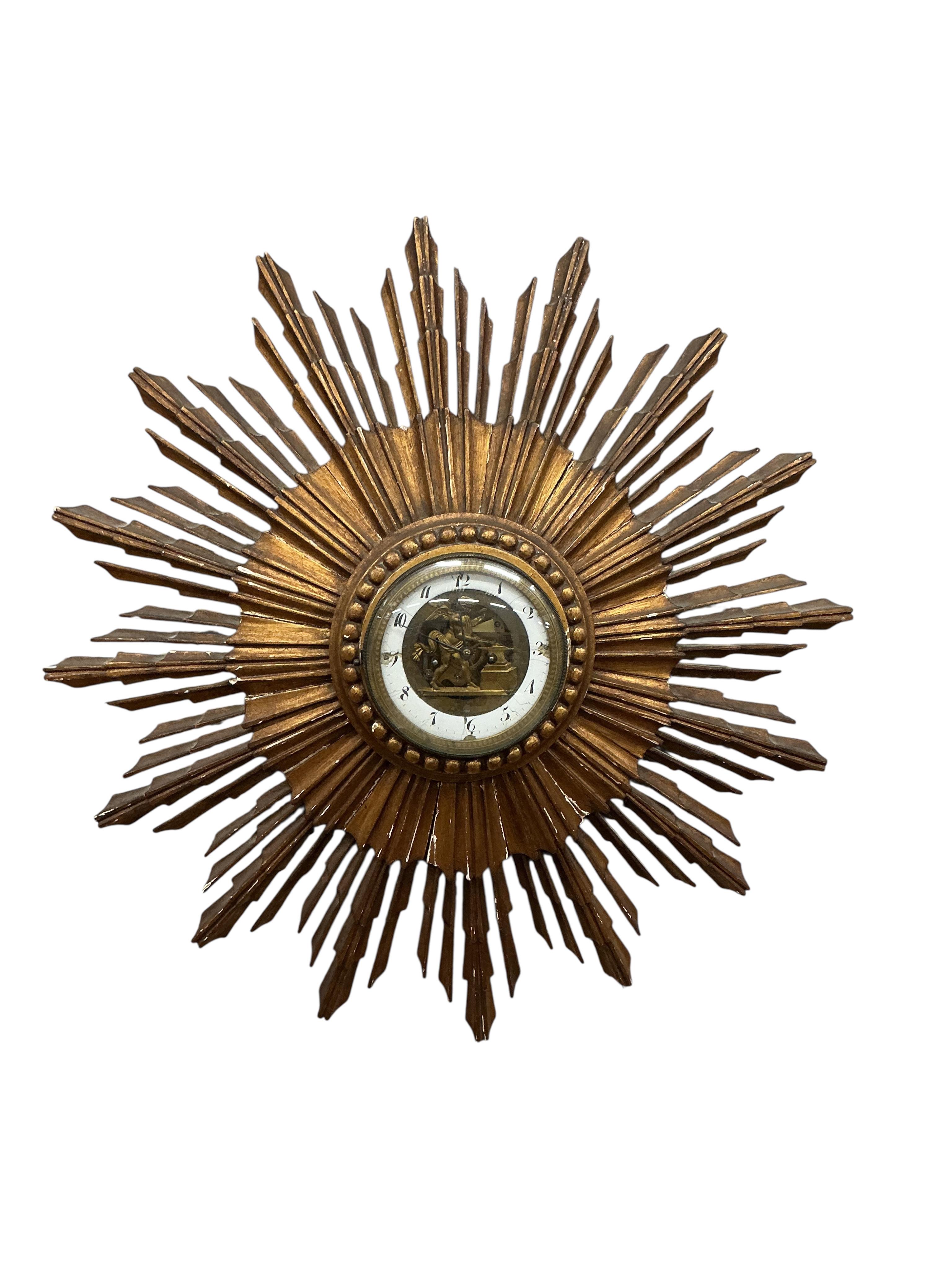 A French giltwood sunburst wall timepiece, with enamelled Roman chapter ring and visible figural escapement, diameter 62cm